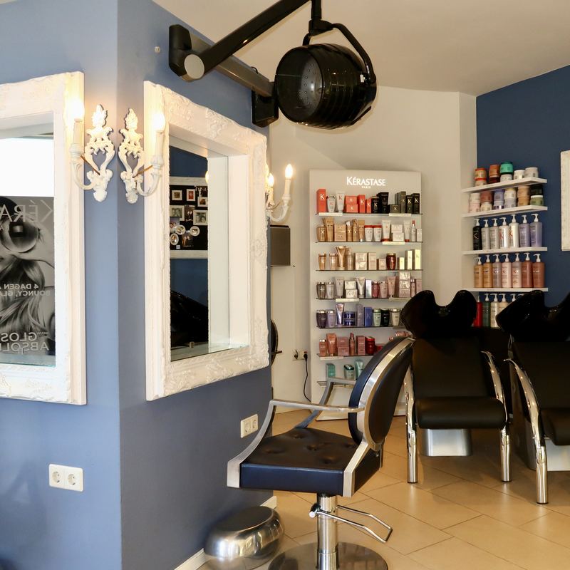 Spiegel en behandelstoel tegen de blauwe muur van de salon